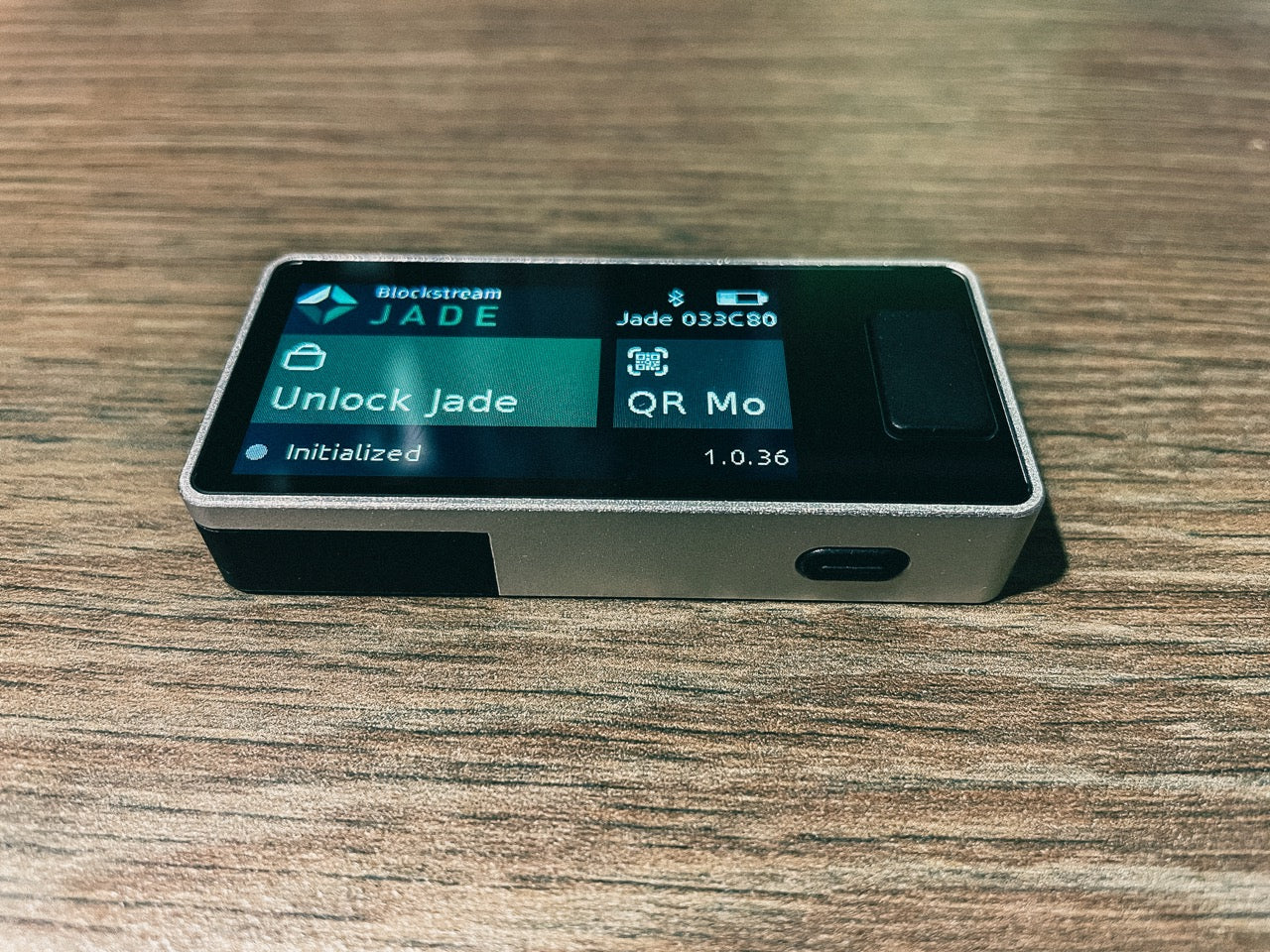 Das Blockstream Jade Plus angeschaltet auf dem Rücken liegend