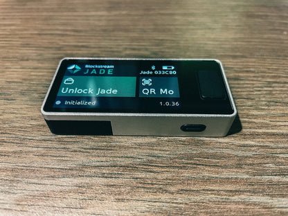 Das Blockstream Jade Plus angeschaltet auf dem Rücken liegend